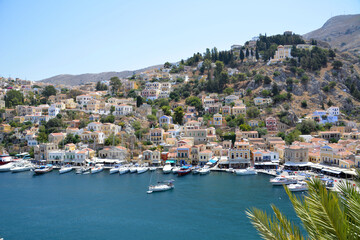 Fototapeta premium a marina with a boat in the water and multicolored houses top view greek island 