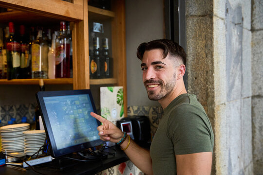 Man using touchscreen in rustic bar setting