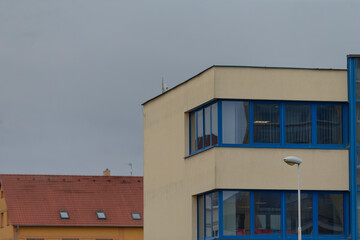 There is a building featuring blue windows along with a street light conveniently positioned right in front of it, enhancing the scene