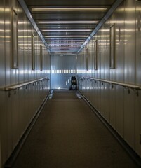 Obraz premium Jet bridge with sunlight patterns at airport.