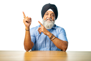 Senior Sikh man sitting at table with white background, expressing various emotions and gestures