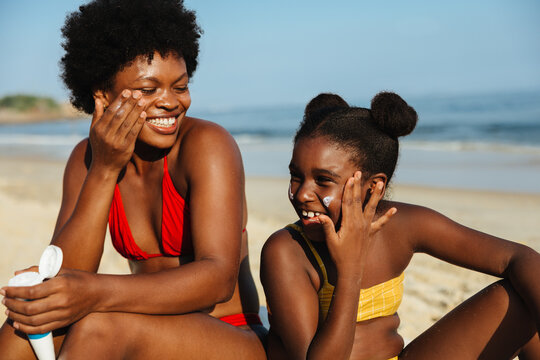 Happy family applying sun protection at the beach