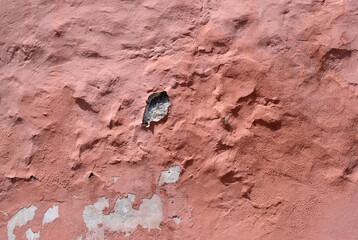 Red Paint Peeling on Old Rough Textured Wall 