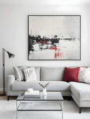 A modern living room with a gray sectional sofa, a single glass coffee table, and a large abstract painting in muted tones.