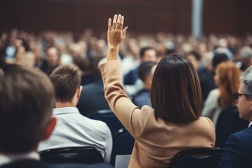 Businesswoman asking question during a conference q and a session, raising her hand to participate