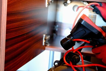 A plumber is trying to open a clogged bathroom pipe using a camera system. Close-up view of opening...