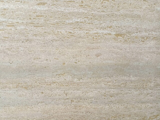 travertine marble texture porous with natural streaks in light brown and gray.
