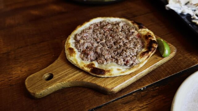 Delicious Arabic meat esfiha served on a board with lemon in a luxurious Arabic restaurant.
