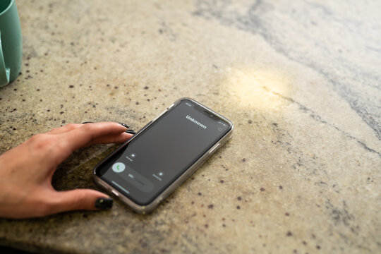 Fraud or fraudulent schemes. Close-up of a woman's hand holding a phone with an unexpected incoming call from an unknown person