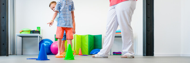 Kids group physio therapy. Children and female physical therapist exercising during session. Bilateral coordination or integration.