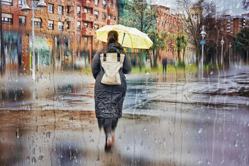 Pedestrian on the street with an umbrella in rainy days in winter season