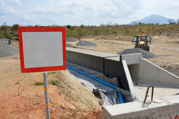 Red-Framed Blank Sign in Front of an Under-Construction Culvert