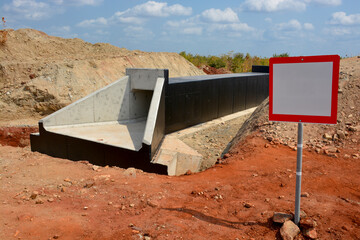 Red-Framed Blank Sign in Front of an Under-Construction Culvert