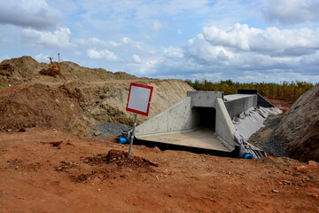 Red-Framed Blank Sign in Front of an Under-Construction Culvert