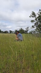 homem sentado em grama fotografando