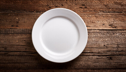 Empty white plate on old wooden table