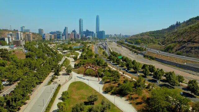 Establishing shot of La B&uacute;squeda statue within Bicentenary park with Santiago behind