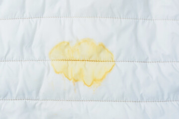 Close up white fabric or upholstery with a yellow stained. The concept of removing daily life...