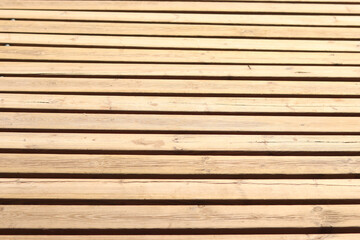 Wooden decking on the beach, close-up on the boards. Boardwalk. Background. Weathered wooden boards...