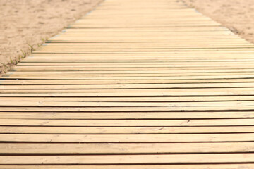 Wooden decking on the beach, close-up on the boards. Boardwalk. Background. Weathered wooden boards...