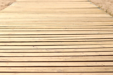 Wooden decking on the beach, close-up on the boards. Boardwalk. Background. Weathered wooden boards...