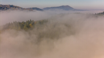 Aerial drone view of sunrise above clouds in mountains