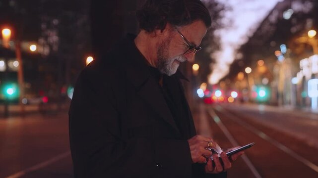 Smiling Mature man using smartphone for online banking, modern applications and convenience of fast 5G connection. Technology enhances efficiency in connected digital world, taxi app on cellphone
