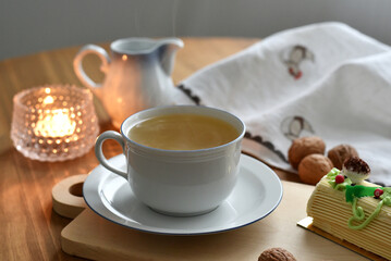 Cup of tea with a cake, candle and rustic decoration
