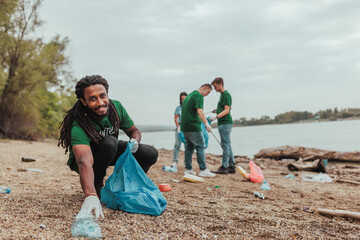 Volunteers collecting trash on river bank: cleaning polluted waters