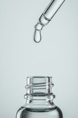 Serum dropper and glass bottle in minimalist skincare concept