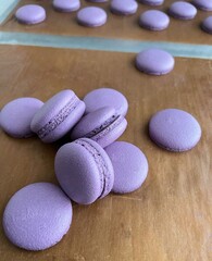 Purple macaron shells, freshly baked and perfectly smooth, resting on a baking mat. A beautiful display of French pastry artistry, ready for assembly into elegant and delicate desserts.