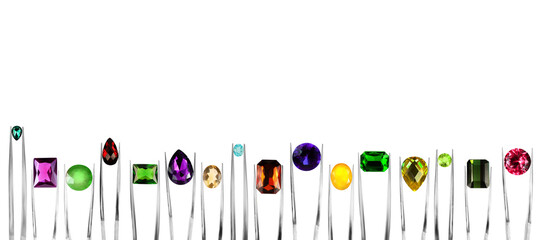Tweezers with different shiny gemstones on white background, set