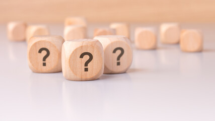 On the table sits a collection of mysterious wooden blocks adorned with question marks