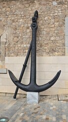 czarna antyczna kotwica przy murze © Miroslaw