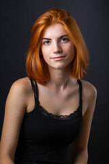 Fototapeta premium Cute red-haired girl, studio portrait on a black background.