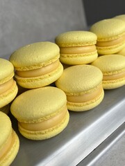 Bright Yellow Macarons with Lemon Cream Filling – Close-Up Perspective. Close-up shot of bright yellow macarons filled with creamy lemon-flavored ganache