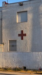 biały budynek z czerwonym krzyżem