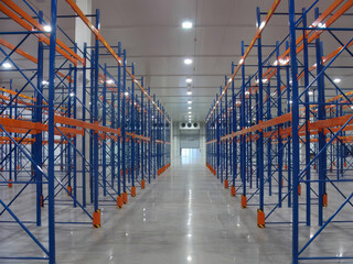 Organized cold storage warehouse with rows of assembled shelving units for product storage.
