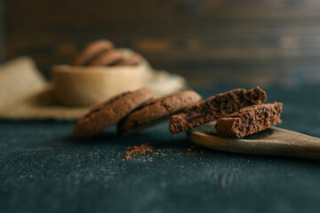Chocolate brownie cookies on wooden spoon, sweets background