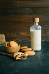 Homemade with chocolate filling on a wooden spoon and a bottle of milk, good morning