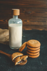 Homemade with chocolate filling on a wooden spoon and a bottle of milk, good morning