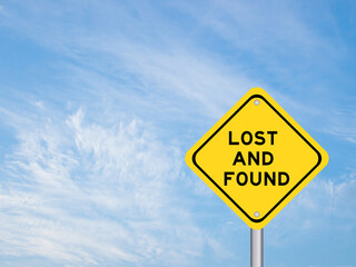 Yellow transportation sign with word lost and found on blue color sky background