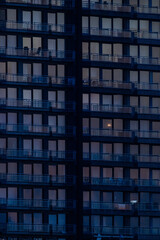 A striking and captivating view of illuminated windows in a dark highrise building during the beautiful dusk