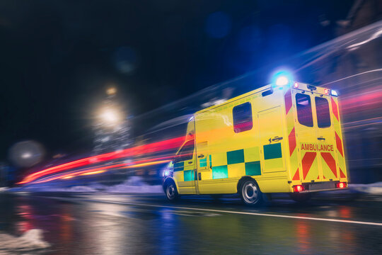 Ambulance car of emergency medical service in blurred motion on road at night. Themes health care, rescue, accidents and disasters..