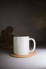 White cup with cork coasters on a light background
