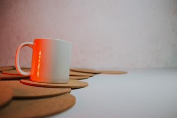 White cup with cork coasters on a light background
