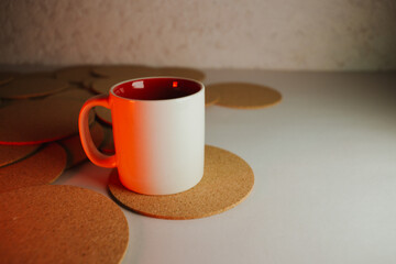 White cup with cork coasters on a light background