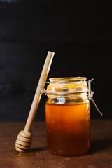 A jar of honey on a dark background