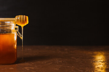 A jar of honey on a dark background