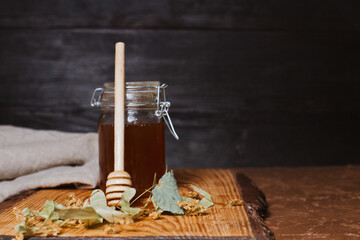 A jar of honey with dry linden leaves